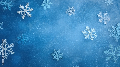 White and silver snowflakes are spread out across the blue background