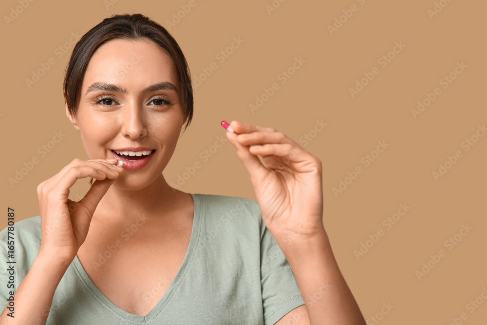 Pretty young woman with pills on brown background Pretty young woman with pills on brown background