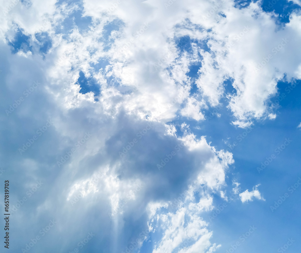 Fototapeta premium Bright blue sky filled with fluffy white clouds, creating a serene and tranquil atmosphere, showcasing the beauty of nature and the vastness of the open sky, inviting peaceful contemplation