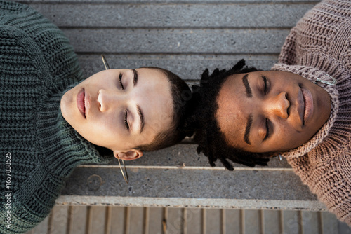 Young women resting while lying on bench