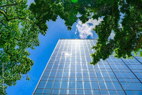 Modern business building in green sustainability eco-friendly environment under blue clean sky