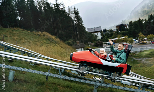 Happy father and daughter on alpine coaster