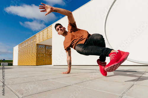 Young man dancing on footpath during sunny day