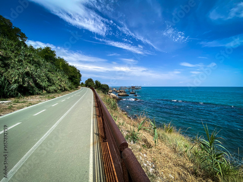 Coastal bike path traversing Trabocchi Coast near Rocca San Giovanni, Abruzzo, revealing traditional fishing platforms and sweeping Adriatic seascape