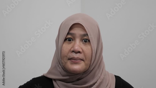 Angry furious Asian muslim woman, full of anger and intensity