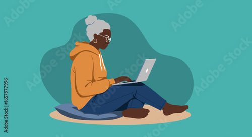 Elderly Black woman sits comfortably, focused on her laptop, embracing technology and digital learning. Modern senior lifestyle.