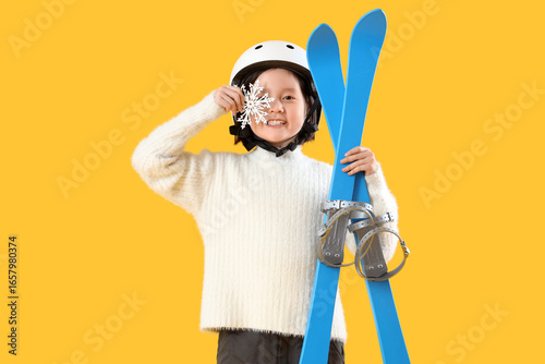 Little Asian girl with skis...