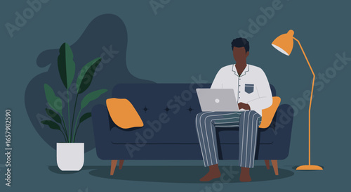 African American man in pajamas using laptop on sofa at home. Ideal for remote work, online education, or comfortable leisure and connectivity.