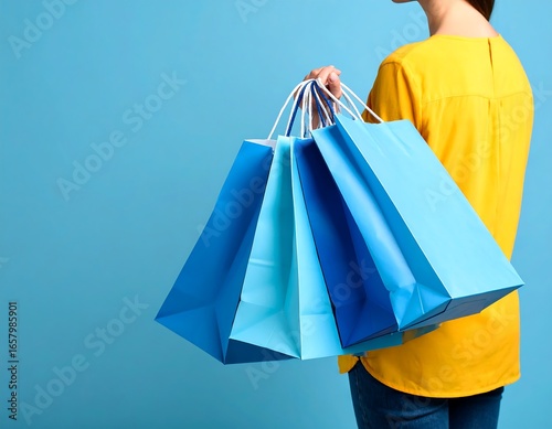 Woman holding shopping bags against a blue background
