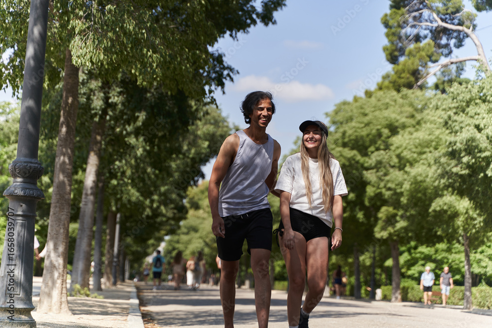 Fototapeta premium Happy couple walking and smiling in a sunny park