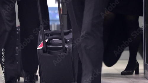 Flight crew exiting the plane with luggage