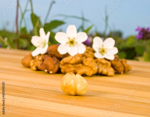 Walnuts and flowers on a wooden board