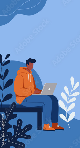 Young man in a hoodie working on his laptop in a relaxed setting. Ideal for themes of remote work, study, or digital lifestyle.
