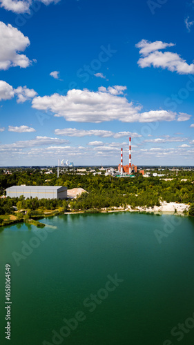 Panorama miasta z turkusowym jeziorem i przemysłowymi kominami,zdjęcie z drona