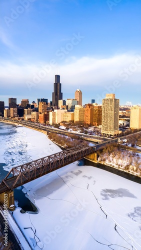 Winter cityscape with frozen river and bridge