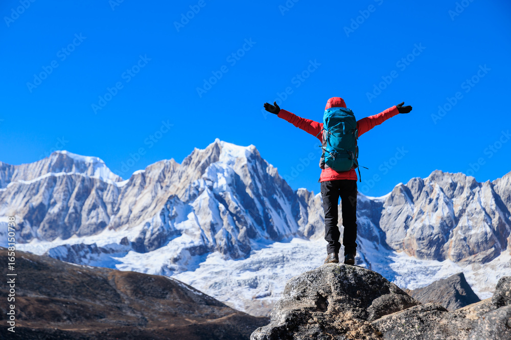 Obraz premium Backpacking woman hiking on high altitude mountain top