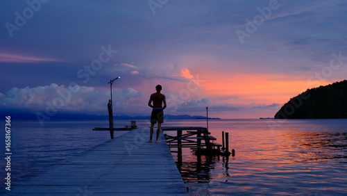Fotografie Colorful sunset over tropical islands with orange and purple sky reflecting on t