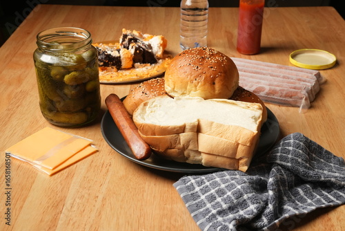 Hamburger, sausage, and sandwich served on a wooden table