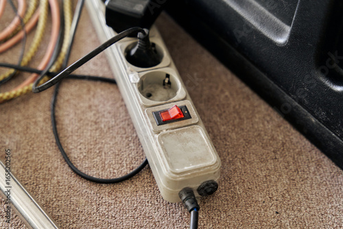 Old and Dirty Electrical Extension Cord with Multiple Sockets and a Red Switch