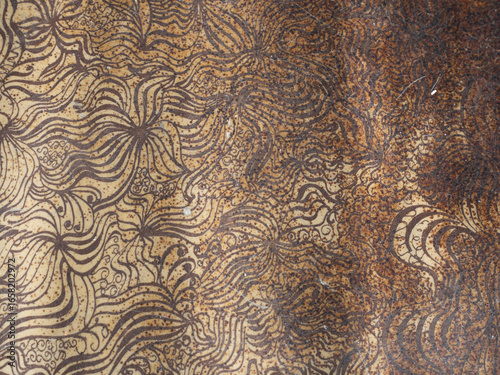 Abstract Floral Pattern on a Worn Brown and Beige Ceramic Tile