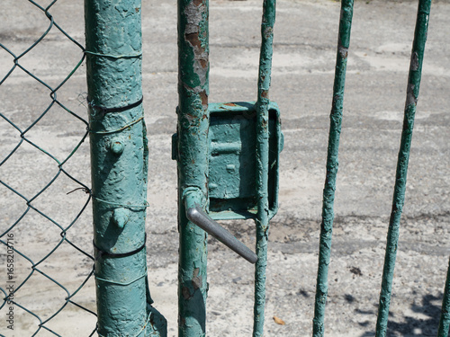 Patina and Peeling Paint on an Old Metal Fence and Gate