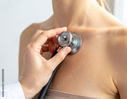 Doctor using stethoscope on patient's chest for examination, healthcare concept.