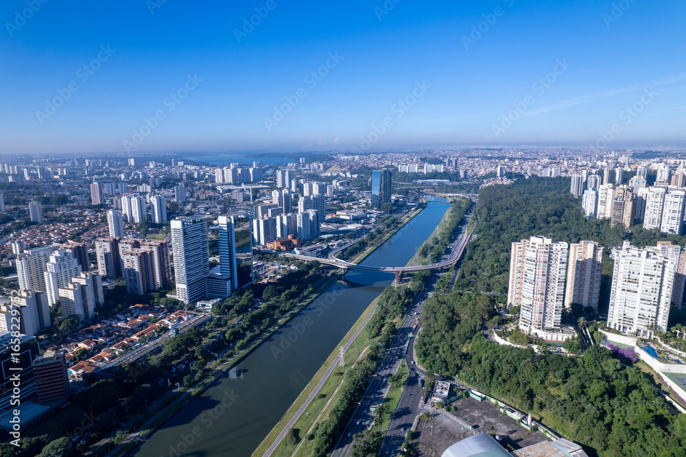 Fototapeta premium Aerial view of Marginal Pinheiros alongside Rio Pinheiros in Sao Paulo showcasing the urban landscape. Residential and commercial buildings in Sao Paulo