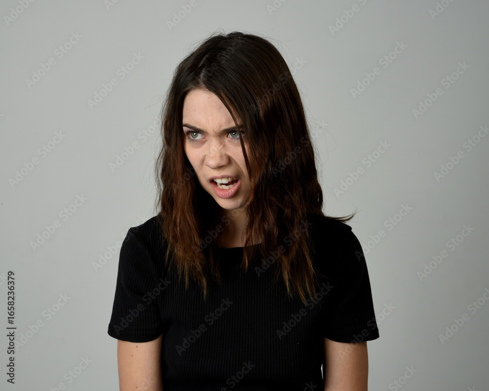 Obraz premium Brunette Girl Model Head and Shoulders Studio Portrait Fresh Faced and Pretty Showing expression emotional upset Expressions