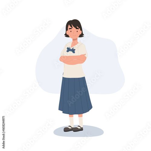 a young thai student in a school uniform standing with folded arms,