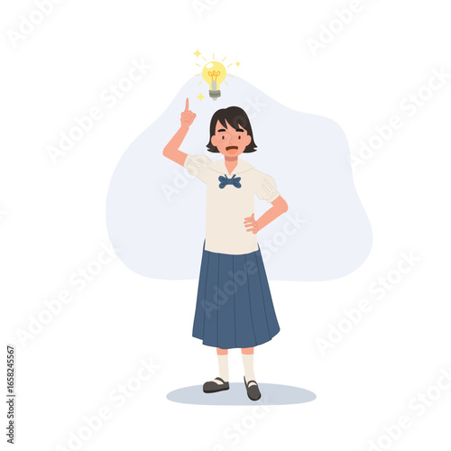 young asian schoolgirl in thai uniform raising finger with light bulb above head shows idea and inspiration for learning creativity and education concept
