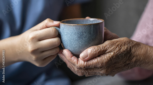 Wallpaper Mural Young hand and elderly hand gently hold ceramic cup symbolizing end of life care with warmth and compassion Torontodigital.ca