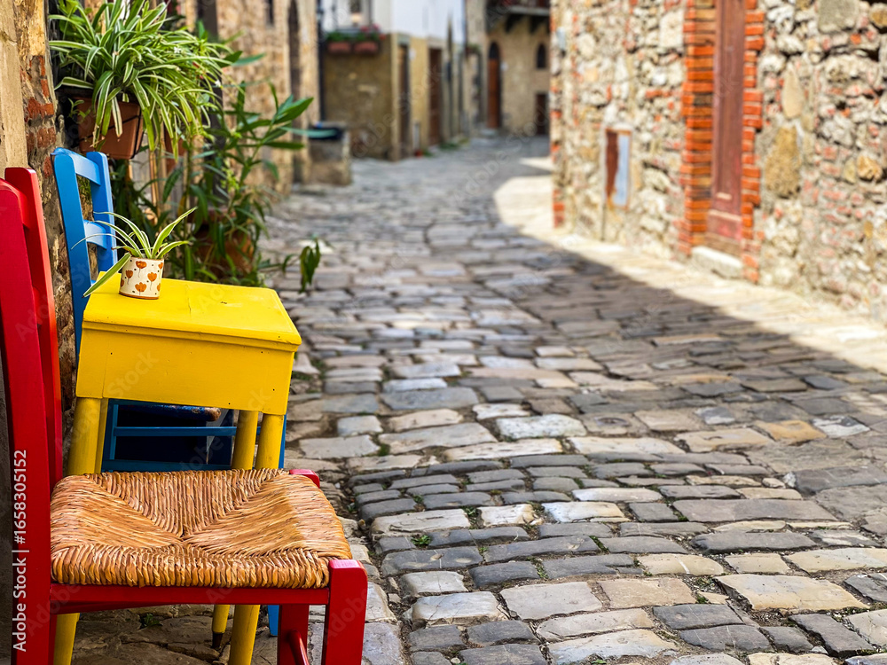 Fototapeta premium Vibrant furnishings enhancing narrow cobblestone passageway in Montefioralle, medieval hilltop village near Greve, capturing quintessential Tuscan charm