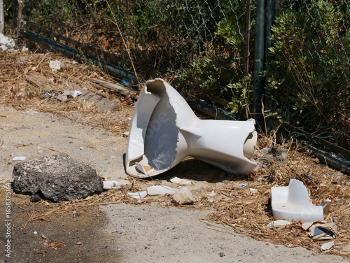 Fotografie Remains of a broken toilet bowl lying on the floor, an example of improper waste