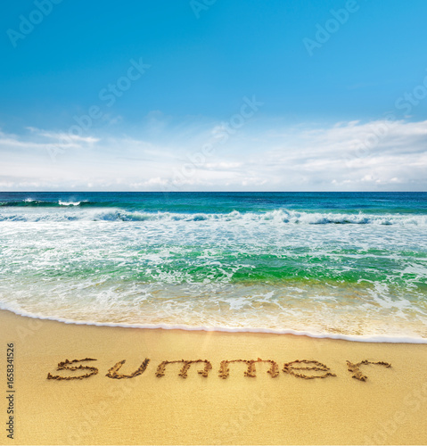 Brandung an einem Tropischen Südseestrand mit dem Wort Summer in den Sand ges...