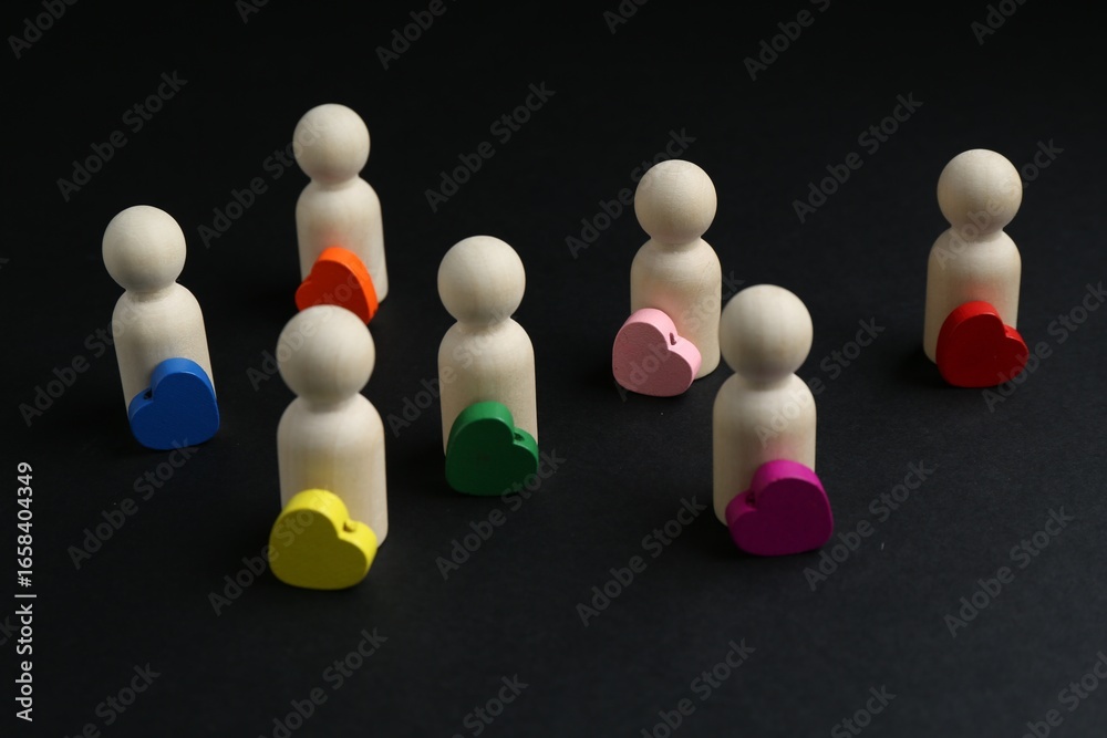 Obraz premium Tolerance concept. Human figures and colorful hearts on black background, closeup