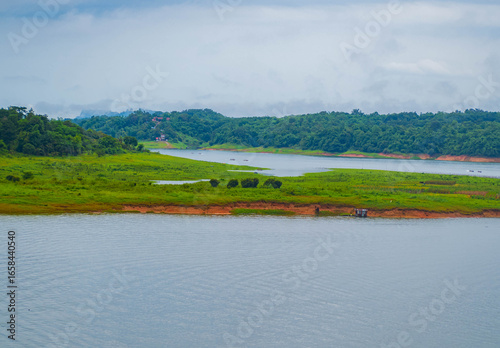 The Mon village in Kanchanaburi with morning mist on the green mountains and clear river.
