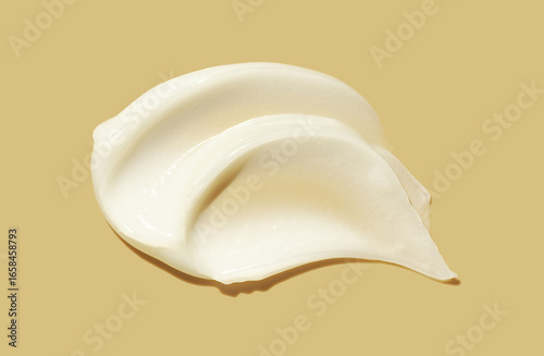 White cream balm swatch isolated on vanilla beige yellow background. Beauty product sample swatch top view. 