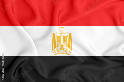 flag of the Arab Republic of Egypt with three horizontal stripes and the coat of arms in the middle on satin fabric with folds and shadows