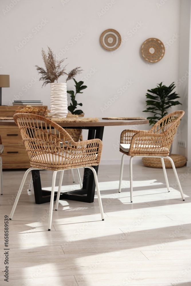 Fototapeta premium Stylish table with chairs and decor in dining room. Interior design