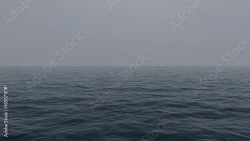 Foggy calm ocean surface under grey sky horizon. Concept of minimalism and quiet solitude