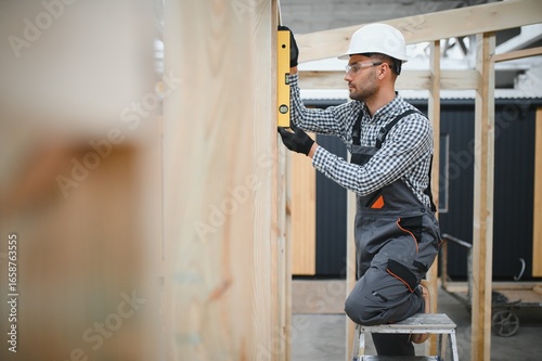 Принти на полотні Worker carpenter assembling a modular house