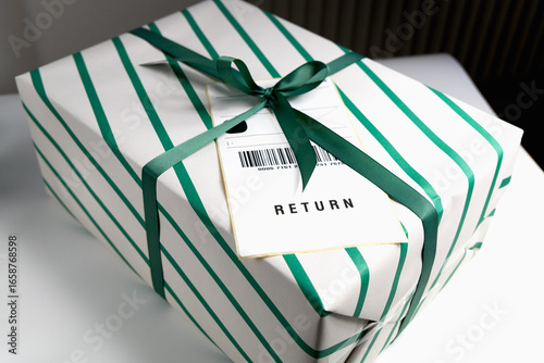 Wrapped gift box with return shipping label and green ribbon