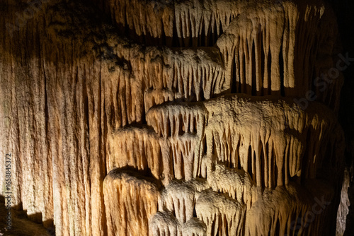 Majestic stalactites and stalagmites in dimly lit mysterious cave