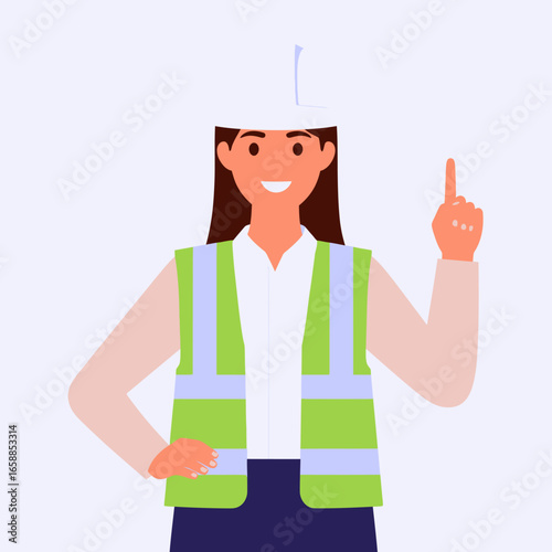 Smiling female engineer in a white hard hat and green safety vest pointing upwards.