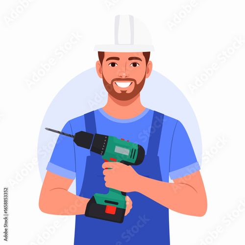 Smiling male construction worker in a hard hat and blue overalls holding a green cordless power drill.