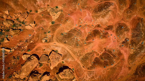 Aerial Red Rock Desert Terrain With Boulder Formations And Sparse Vegetation