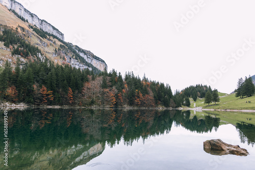 Spiegelung der Berge und Wälder im klaren und spiegelglattem Bergsee im Herbst