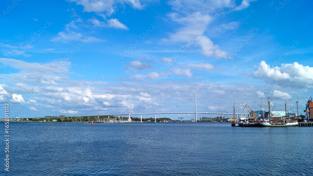 Fototapeta premium Rügen Bridge photographed from a distance under a blue sky with few clouds – scenic view of the Baltic Sea connection in Germany.