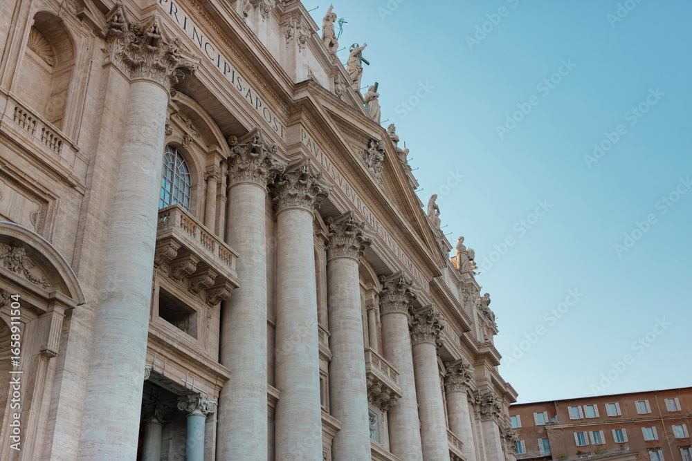 Fototapeta premium Detailed facade of St. Peter's Basilica showing classical columns and papal inscriptions