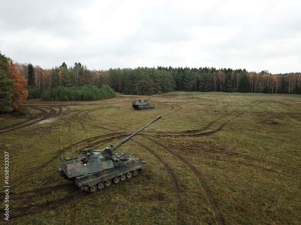 Fototapeta premium Aerial view of two PzH 2000NL artillery systems positioned in autumn field